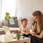 Woman working at home with child